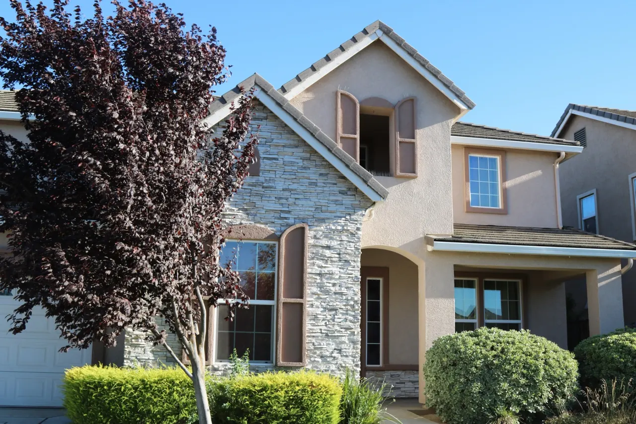 The stone-front entrance and trees at Bellevue Ranch House